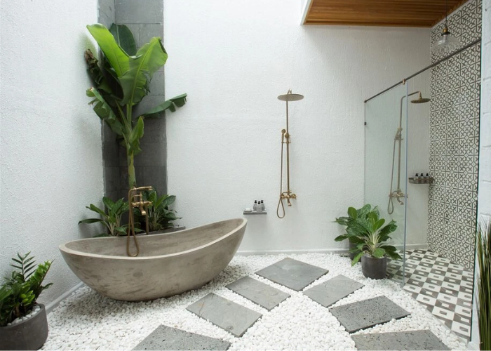 Phòng tắm tự nhiên với nhiều cây xanh và sử đá sỏi lát nền làm điểm nhấn