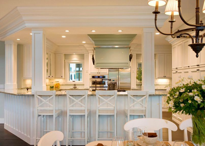 Quầy bar bếp màu trắng có mặt bàn bằng đá kết hợp với tủ bếp cùng màu làm cho không gian trở nên rộng rãi và thoáng đãng hơn