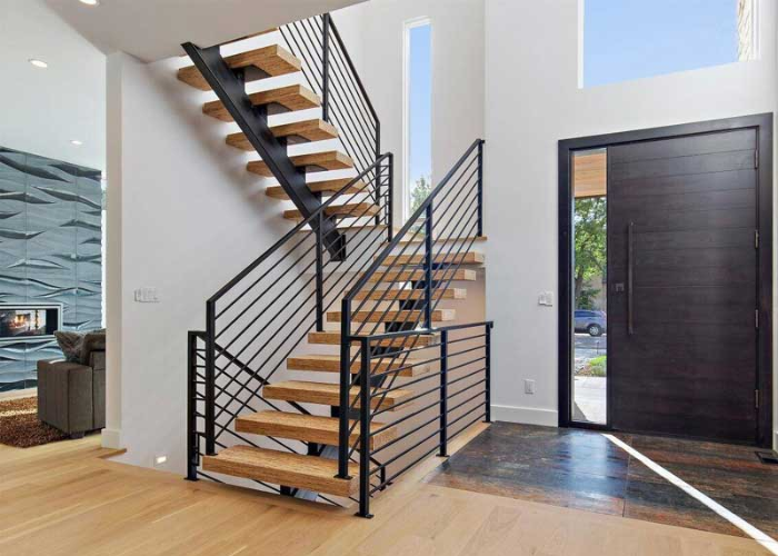Thiết kế cầu thang chịu lực bằng gỗ, tay cầm sắt và có vách ngăn cầu thang là các thanh sắt xếp đều nhau
