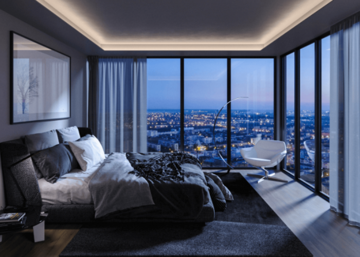 Phòng ngủ màu xanh xám với hướng nhìn thẳng ra cửa sổ lớn, ngắm trọn khung cảnh thành phố về đêm.   