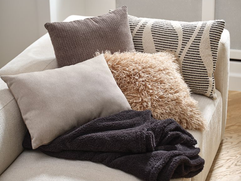 Một bộ gối sofa gồm 2 gối sofa đơn sắc, 1 gối trang trí với họa tiết độc đáo, và 1 gối tựa lưng lông đặt trên sofa bed sẽ tạo nên một góc phòng khách chuẩn Bắc Âu
